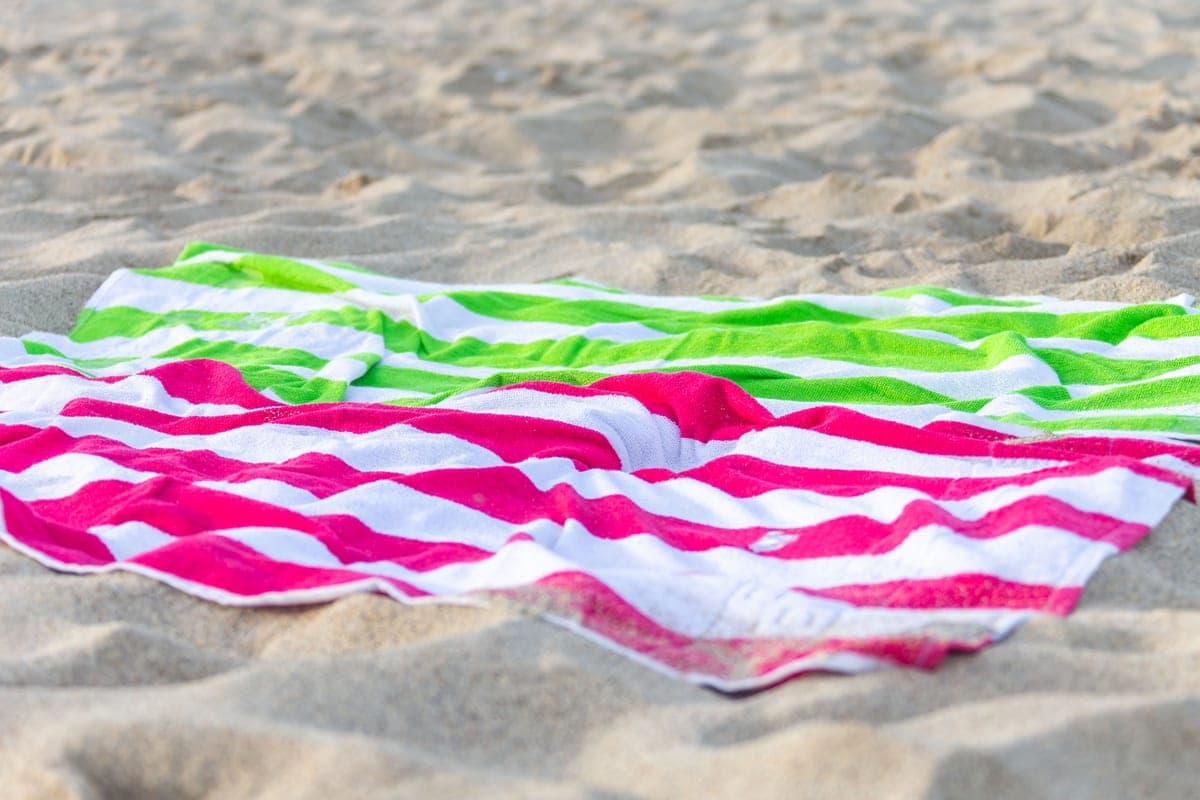 A beach towel laid out on the sand
